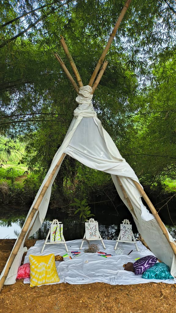 Picnic and painting setup under bamboo teepee